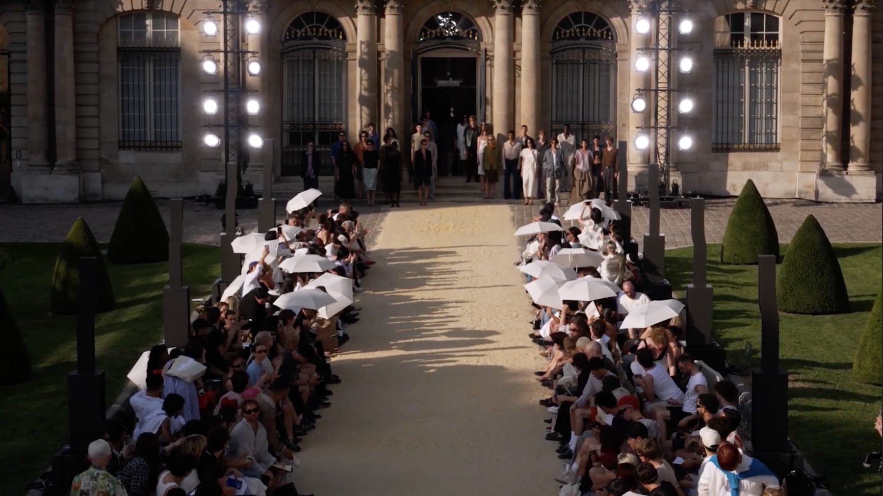System Spring/Summer 2027 show, white parasols along a sand runway — image 04