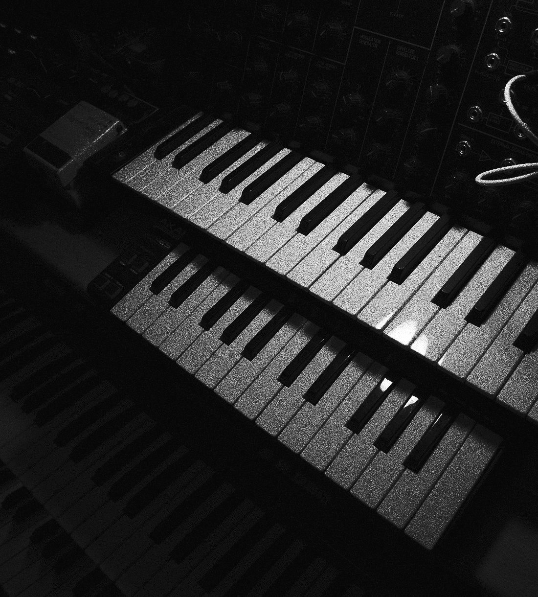 Two keyboards stacked in front of a modular synthesiser